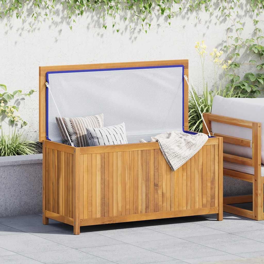 An outdoor scene with a wooden storage box filled with cushions and a blanket, next to a chair.