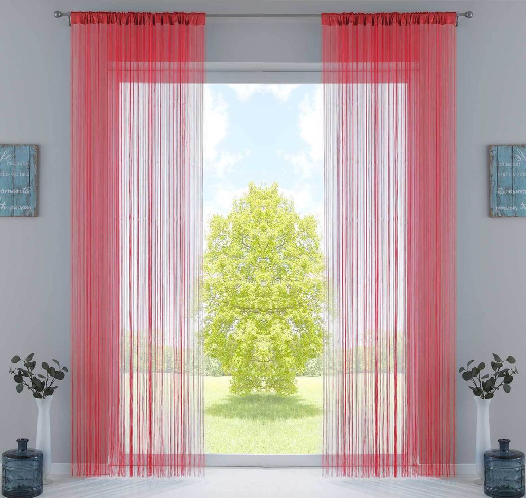 A room with a large window covered by red string curtains, with a tree visible outside.