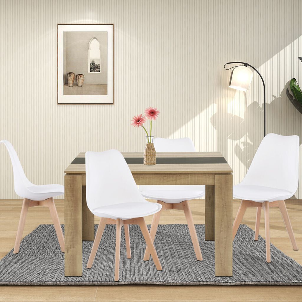 A dining table with four chairs in a room.