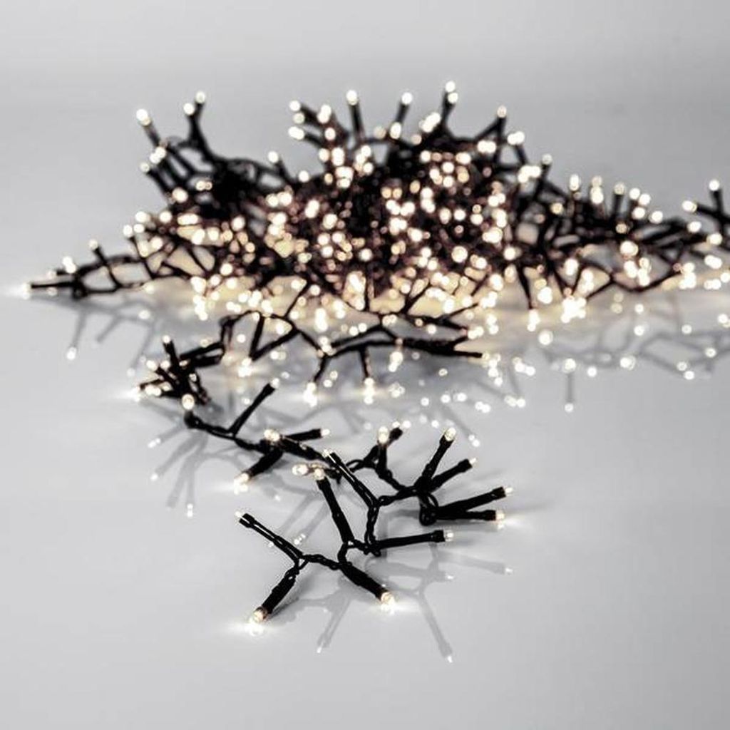 A string of white LED lights with black wires, arranged in a cluster on a reflective surface.
