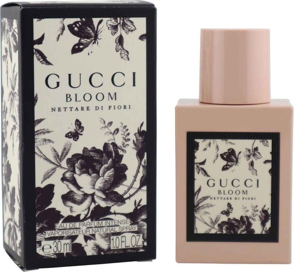 Rechteckiger Gucci Bloom Flakon in Rosa neben floral bedruckter Box mit Schmetterlingen und Rosenmuster.
