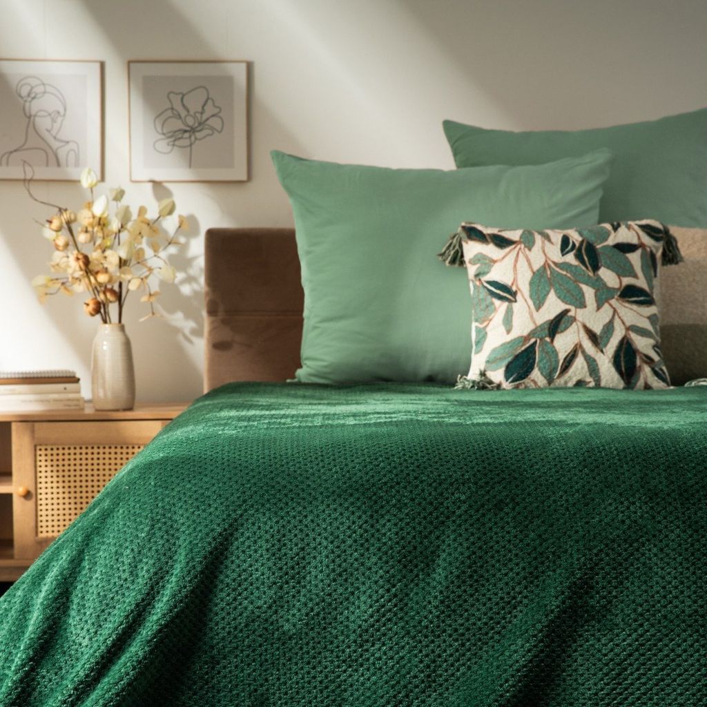A bedroom setting with a bed, pillows, and a nightstand.