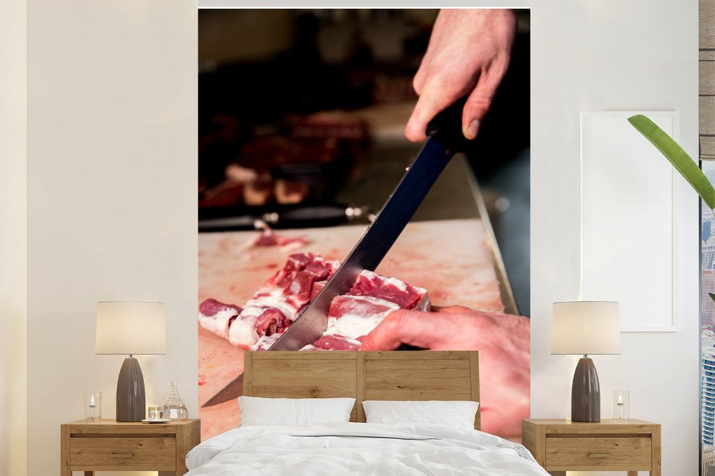 MuchoWow Fototapete für Wohnzimmer oder Schlafzimmer Wandtapete Vinyl Motivtapete Ein Fleischer schneidet das Fleisch mit einem Messer - 155x240...