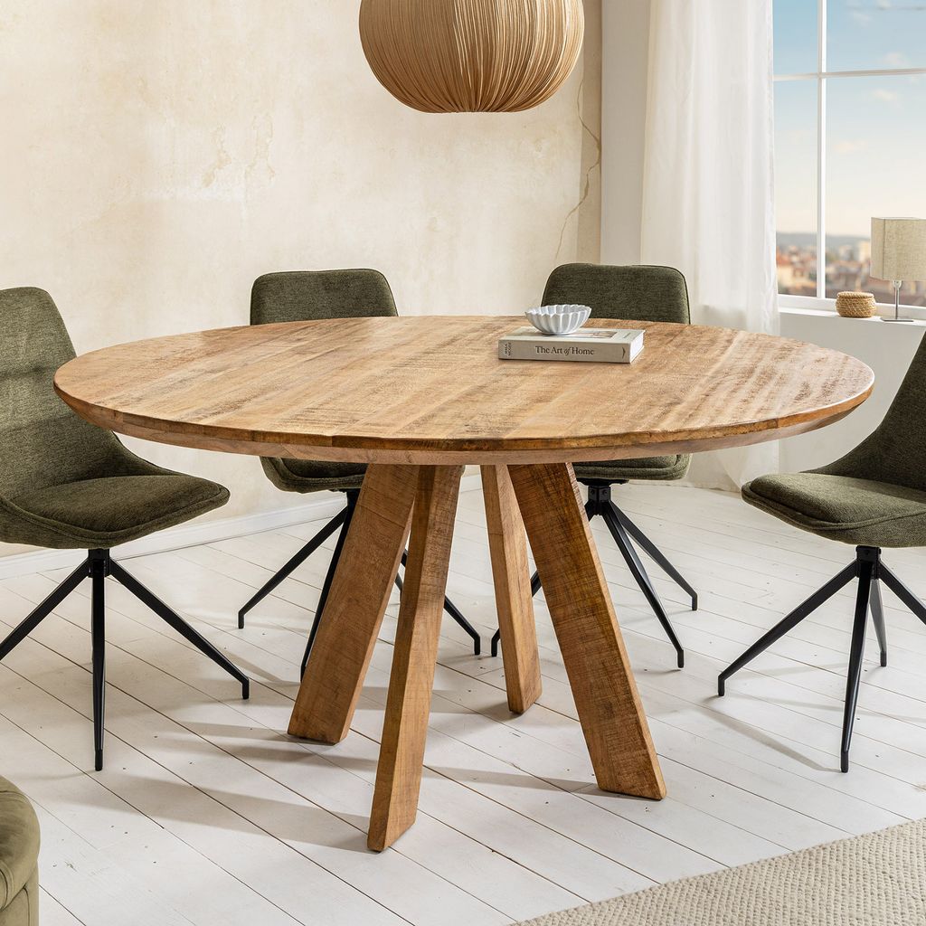 A round wooden dining table with four green chairs in a dining room setting.