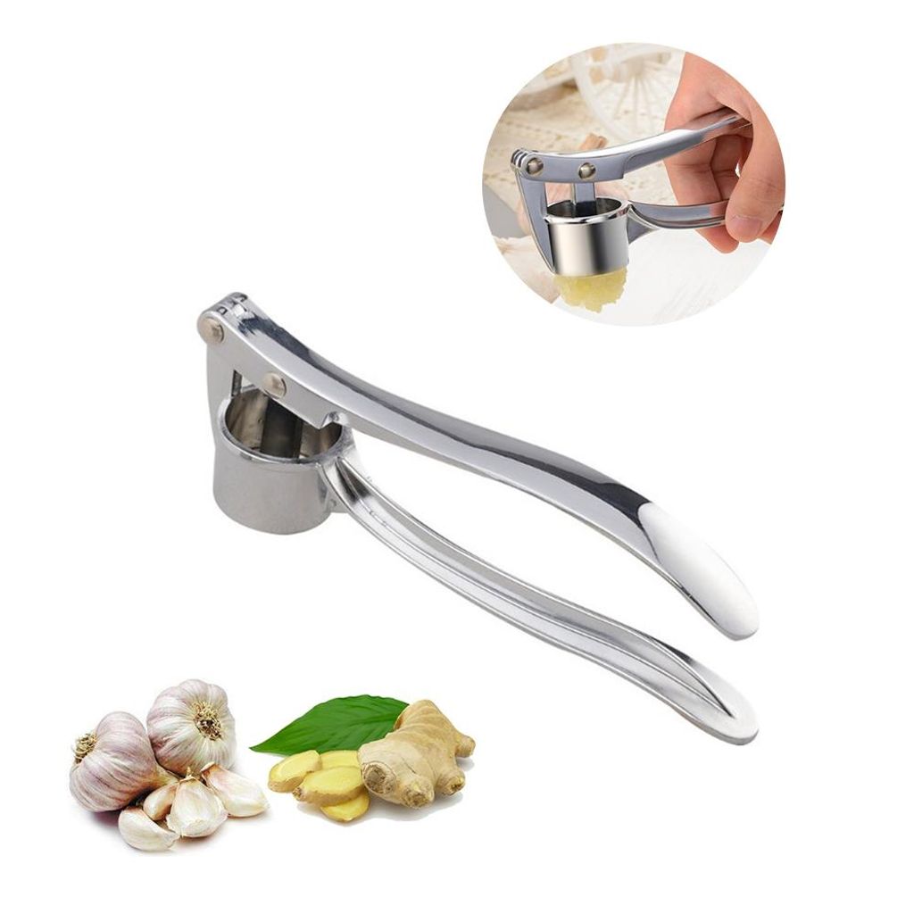 A stainless steel garlic press with a white handle, shown on a white background. There are also some garlic bulbs and ginger slices in the lower left corner. A small inset image shows the garlic press in use.