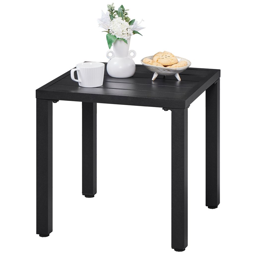 A black metal side table with a white mug, a vase with flowers, and a bowl of cookies on top.