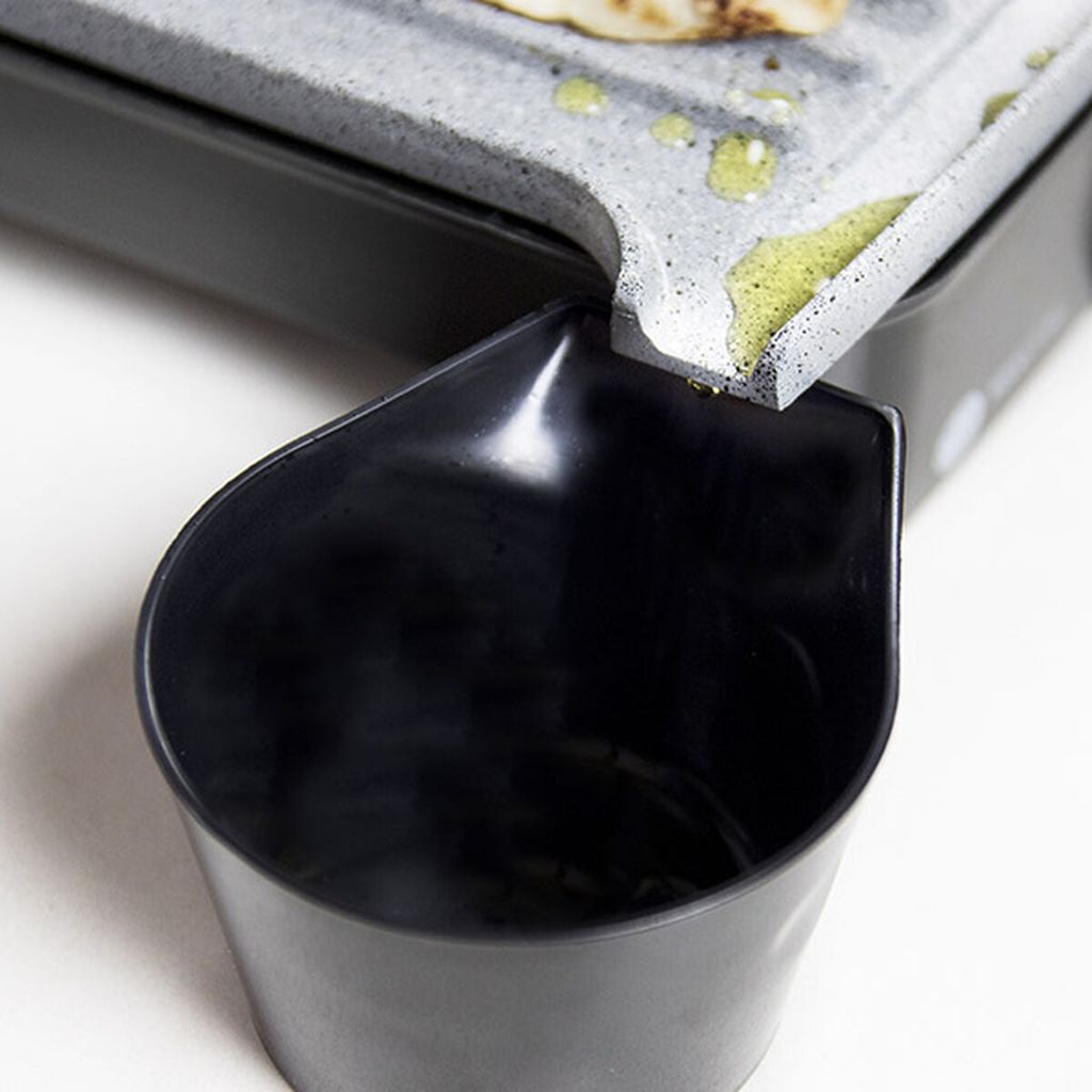 A close-up of a grill with a drip tray.