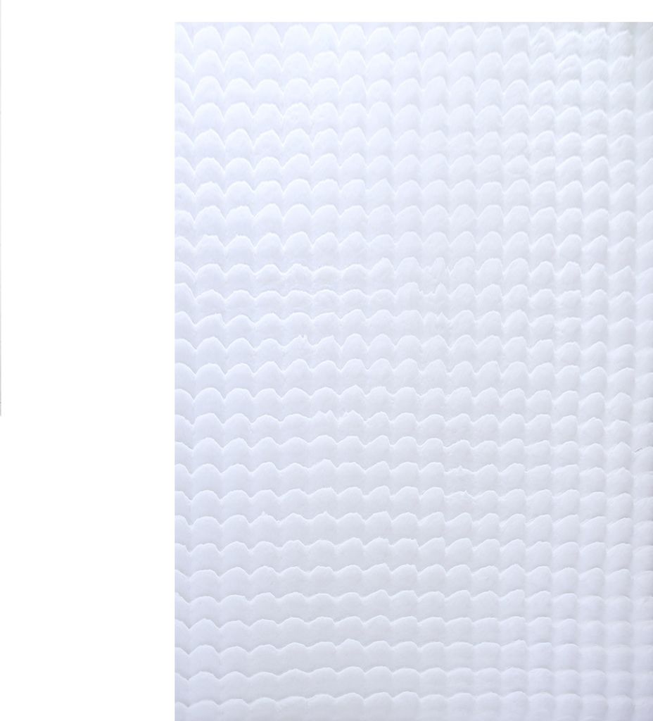 A close-up view of a white, textured rug with a wave-like pattern.