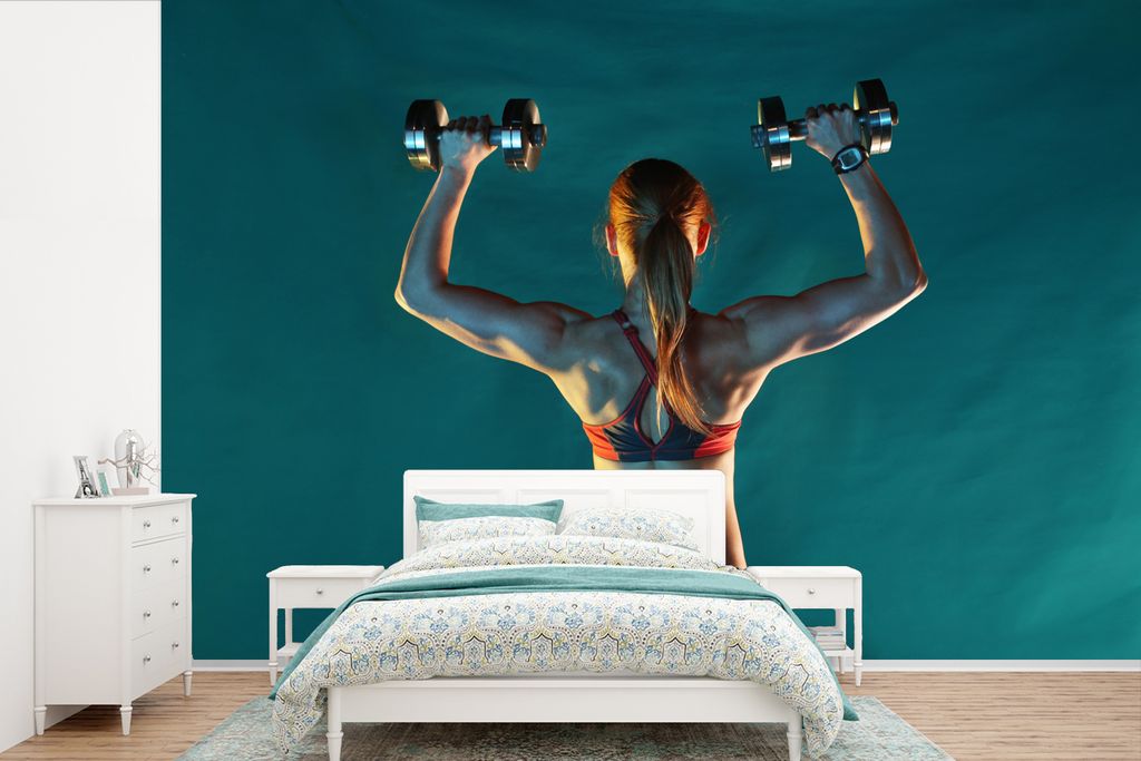 MuchoWow Fototapete für Wohnzimmer oder Schlafzimmer Wandtapete Vinyl Motivtapete Eine Frau hält beim Fitness zwei Gewichte hoch - 420x280 cm -...