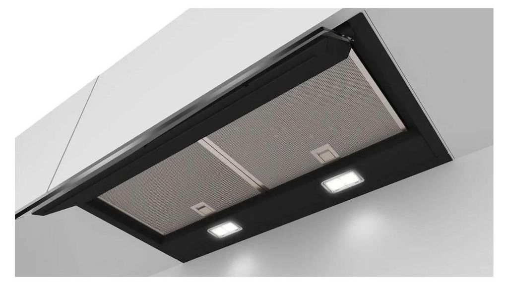 A close-up view of a black range hood installed under a white kitchen cabinet.