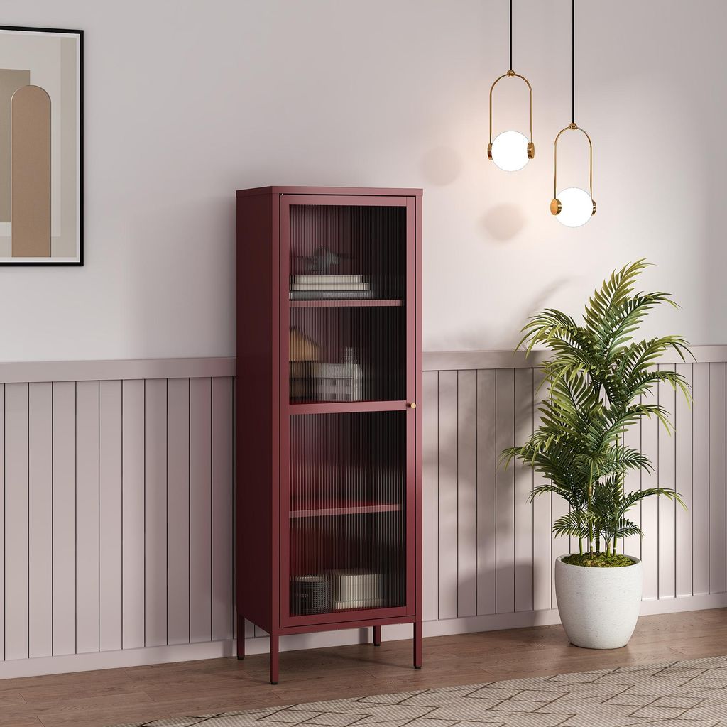 A tall, narrow cabinet with glass doors stands in a room with decorative wall paneling and a large potted plant.