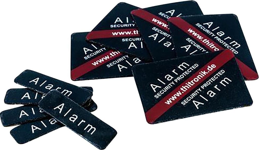 A pile of alarm stickers with text and a website address.