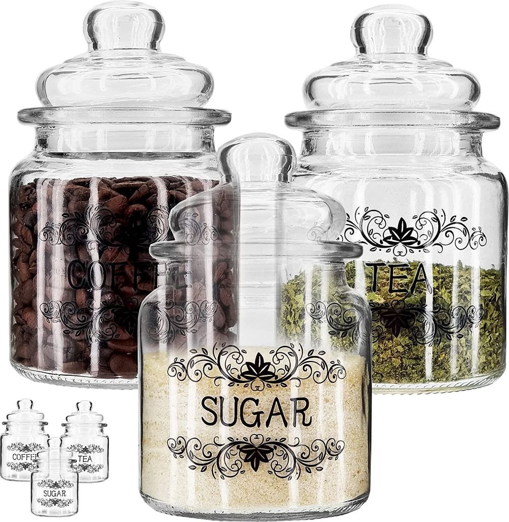 Three glass jars with lids, filled with coffee beans, tea leaves, and sugar, are arranged on a white background. Smaller versions of the jars are visible in the foreground.