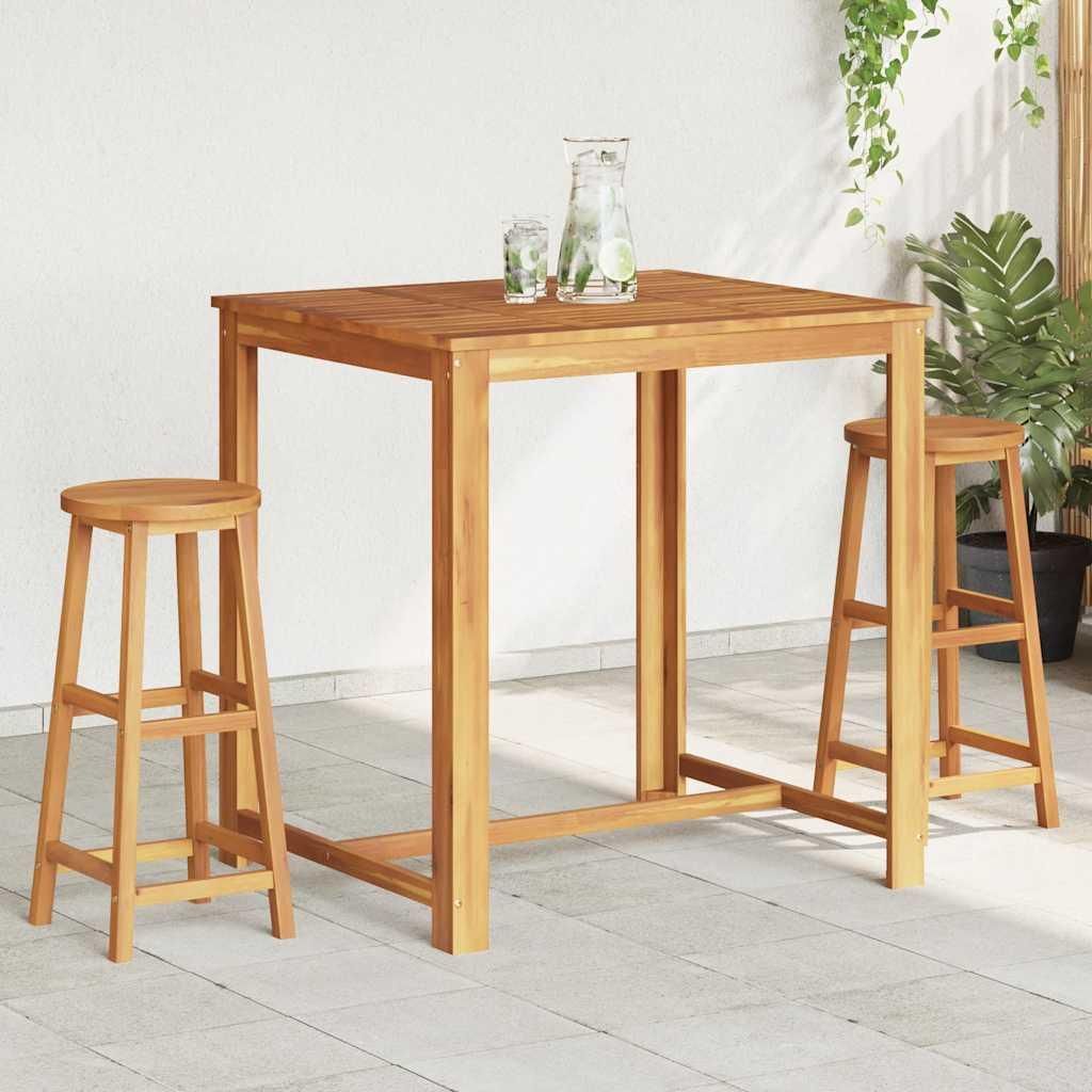 A wooden bar table and two bar stools are set up on an outdoor patio.