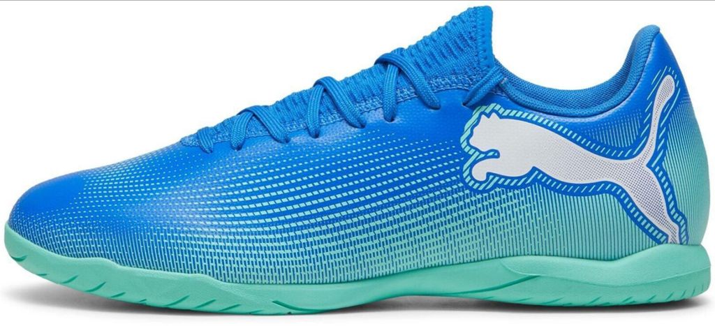 A side view of a blue and green Puma soccer shoe.