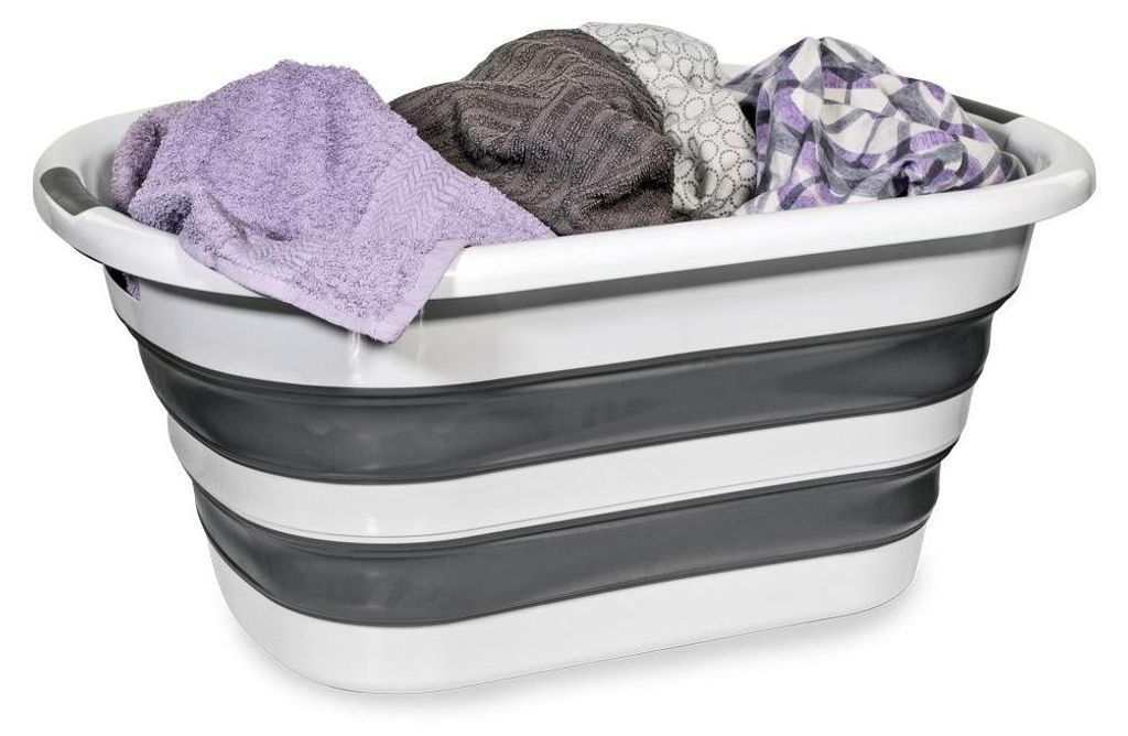 A collapsible laundry basket filled with folded towels and clothes.