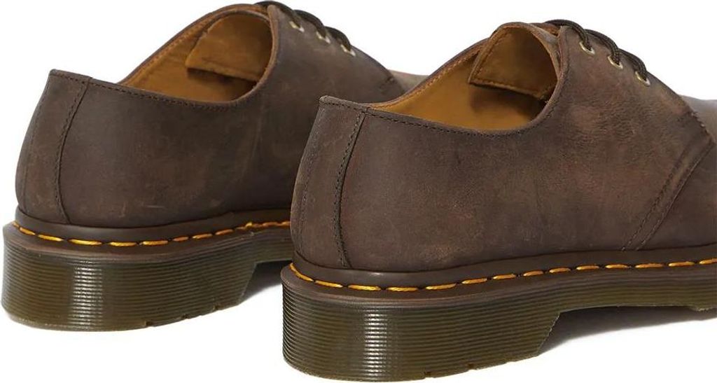 A close-up side view of two brown leather shoes.