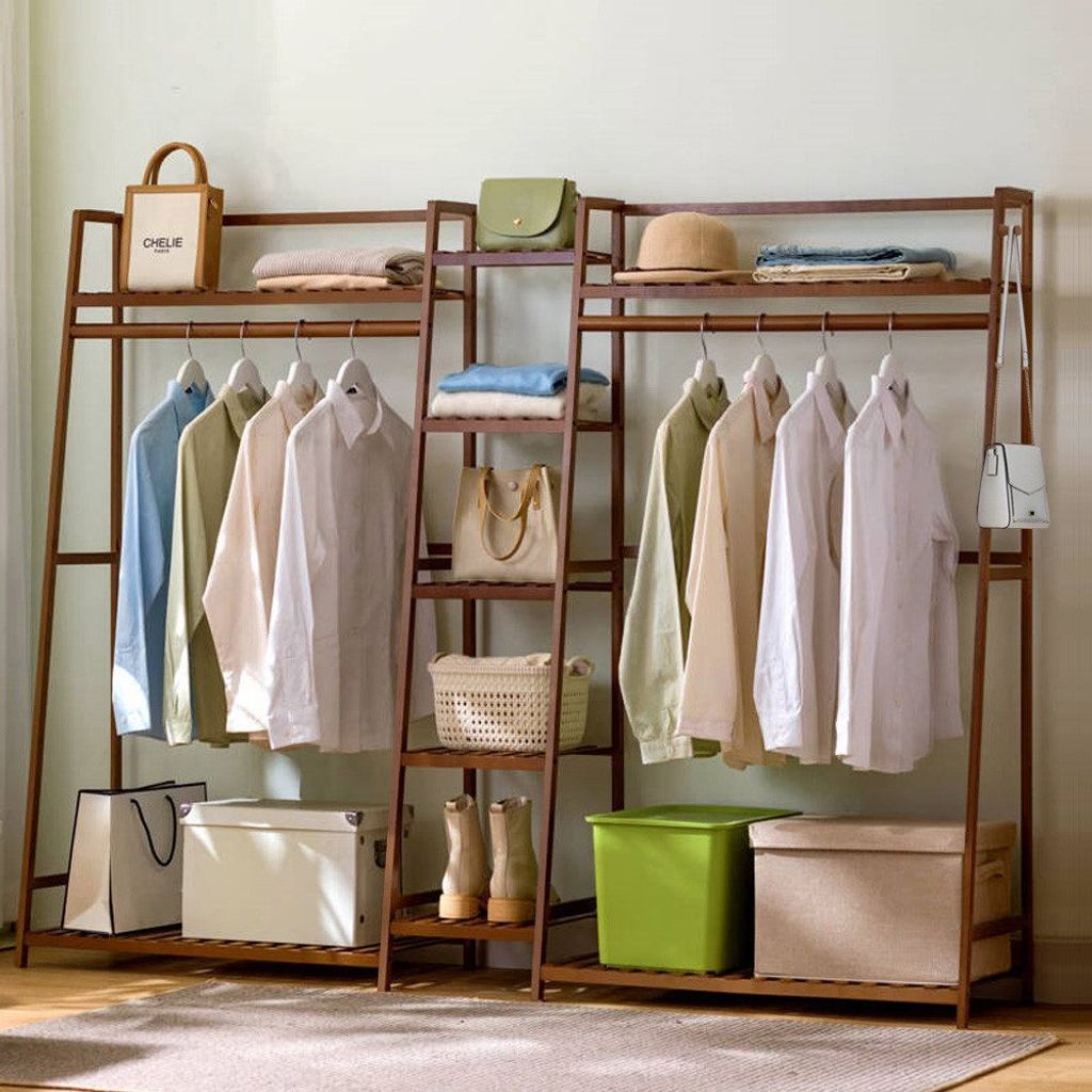 A bamboo garment rack with clothes and storage items.