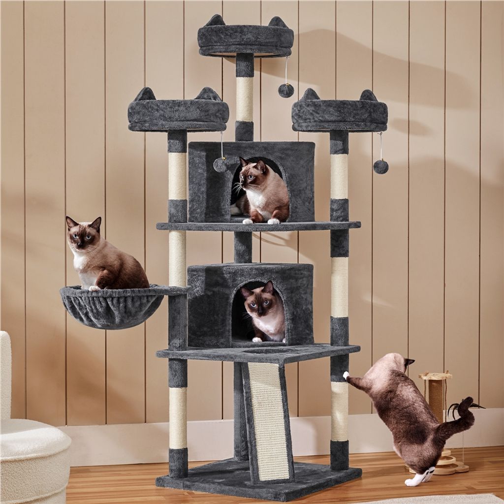 A multi-level cat tree with several cats interacting with it, set against a wood-paneled wall.