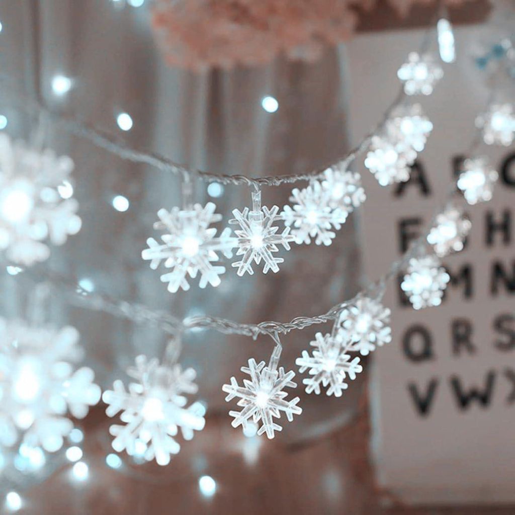 A close-up of snowflake-shaped LED string lights, likely for holiday decoration.