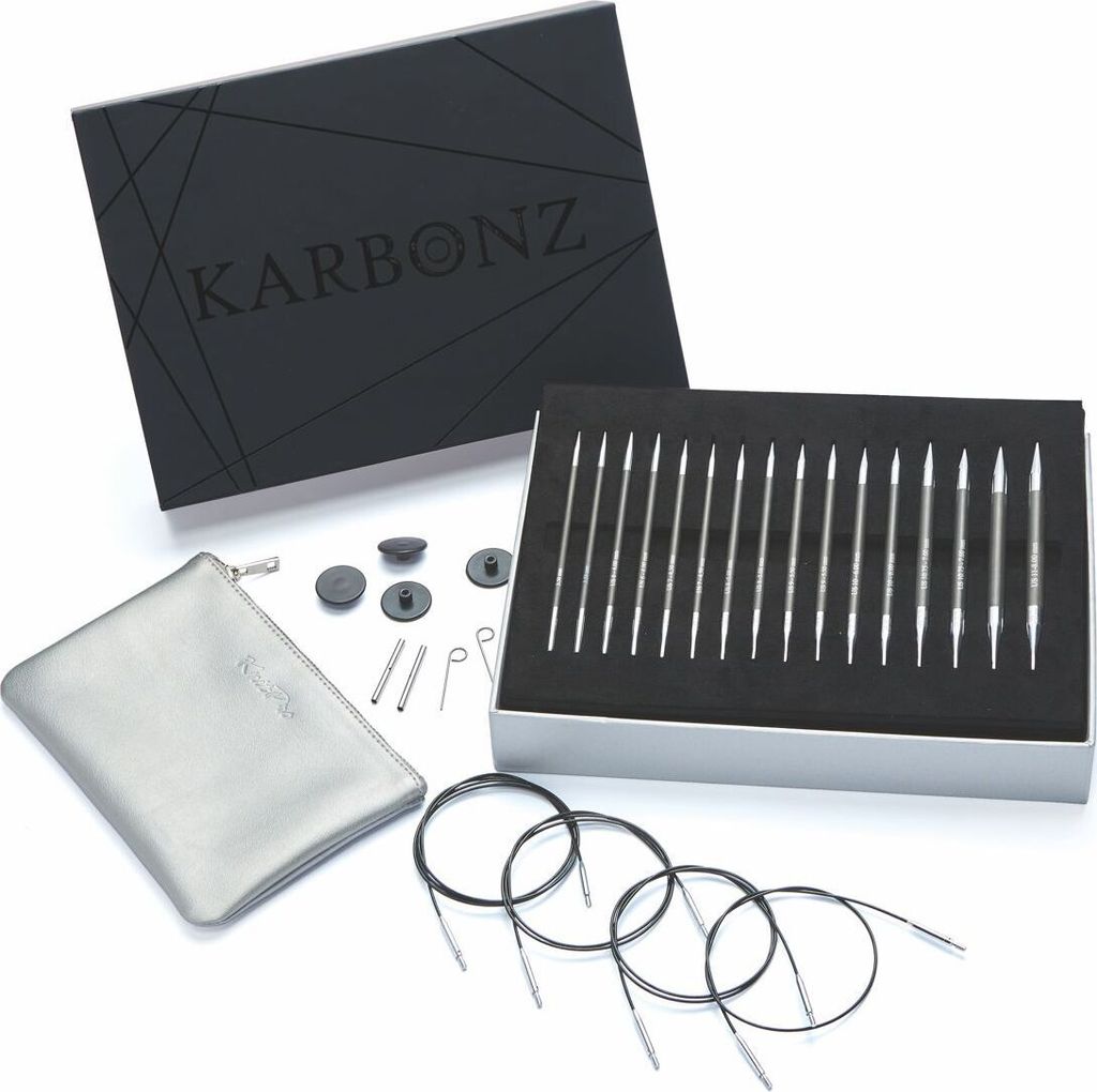 A set of knitting needles and accessories is displayed on a white background, with the product box open.