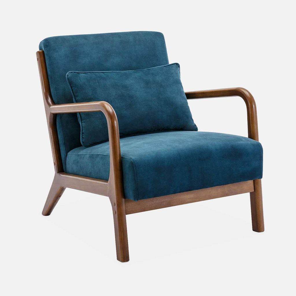 A studio shot of a blue armchair with a wooden frame.