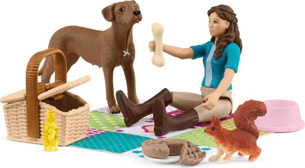 A toy picnic set with a girl, a dog, a squirrel, a picnic basket, food, and a bowl.
