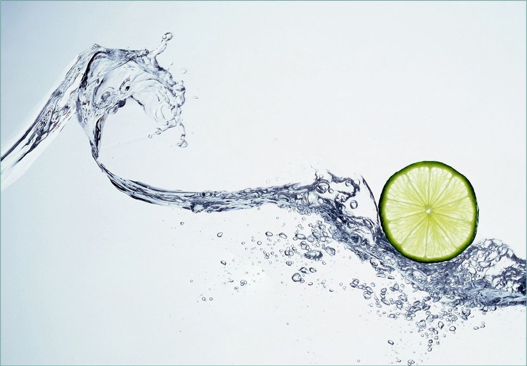 Wallario Fototapete Vliestapete, seidenmatte Oberfläche, einfache Verarbeitung, Größe 200 x 140 cm, Motiv Limettenscheibe in spritzigem Wasser