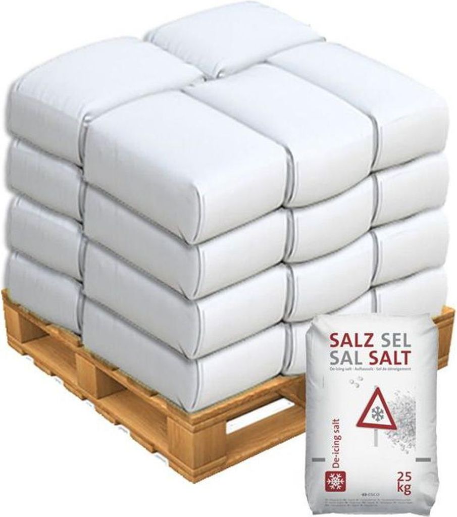 A pallet stacked with bags of de-icing salt, with one bag in the foreground.