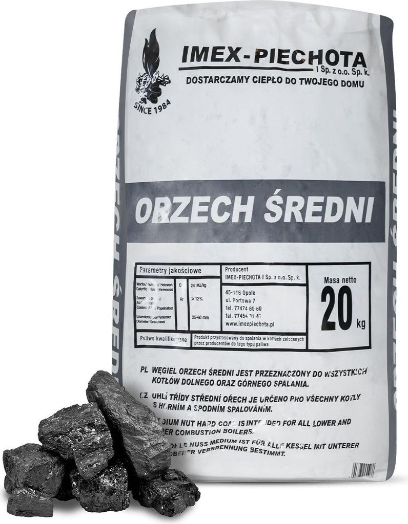 A bag of coal with some loose pieces in front of it.