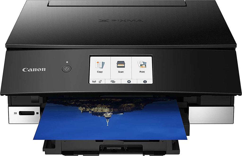 A black Canon PIXMA TS8350a inkjet printer is shown from the front, printing a photograph.
