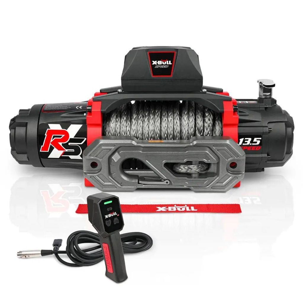 A black and red electric winch with a coiled steel cable, a remote control, and a red strap, displayed on a white background.