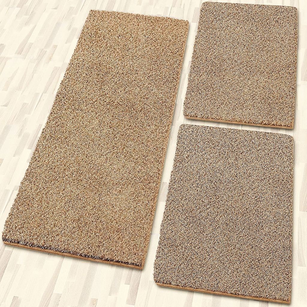 Three beige rugs of different sizes are arranged on a light-colored wooden floor.