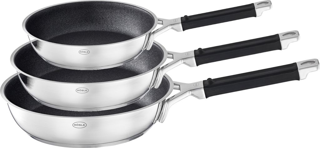 A set of three stainless steel frying pans with black handles, stacked on a white background.