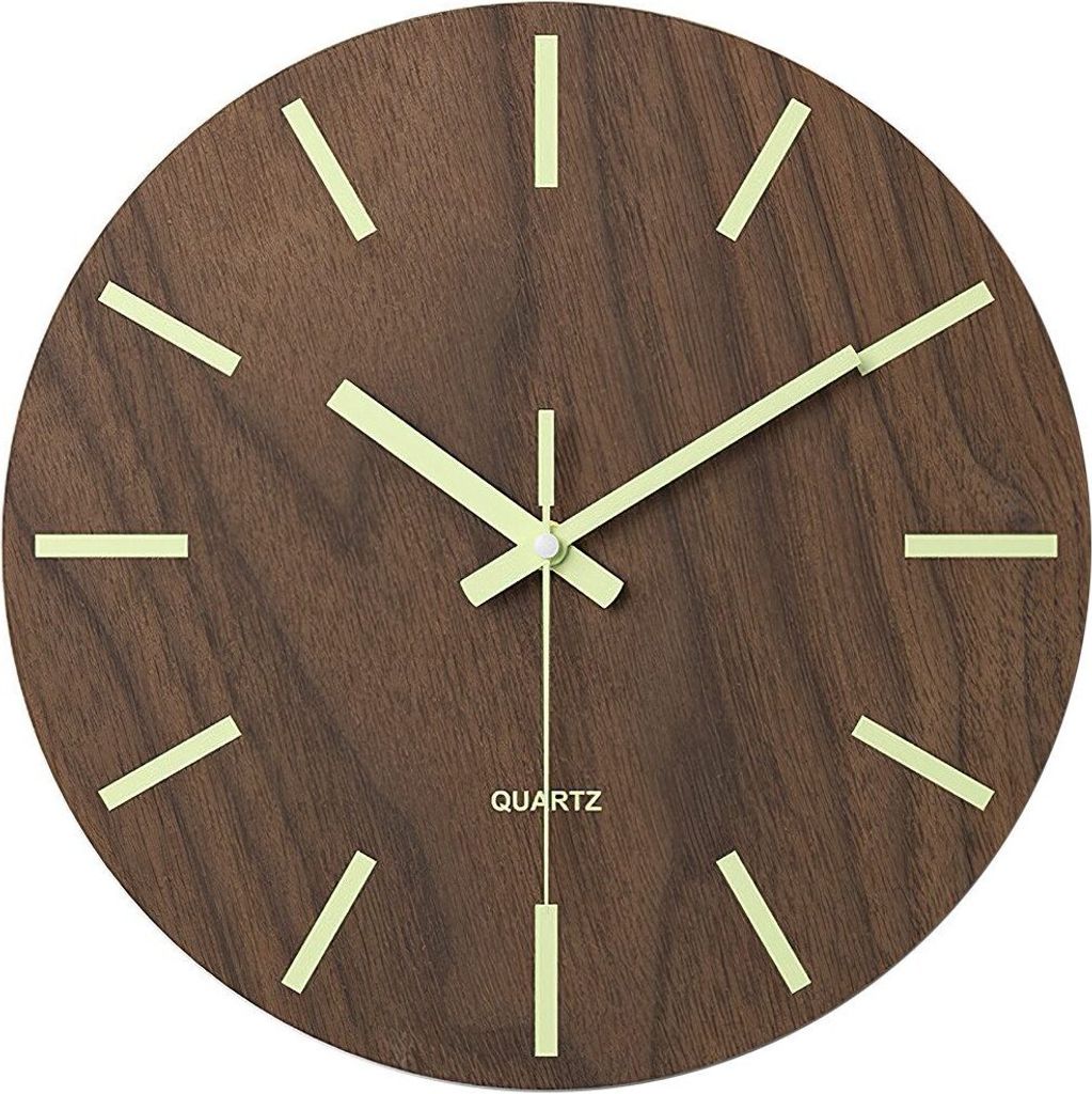 A close-up shot of a wooden wall clock with luminous hour markers and hands.