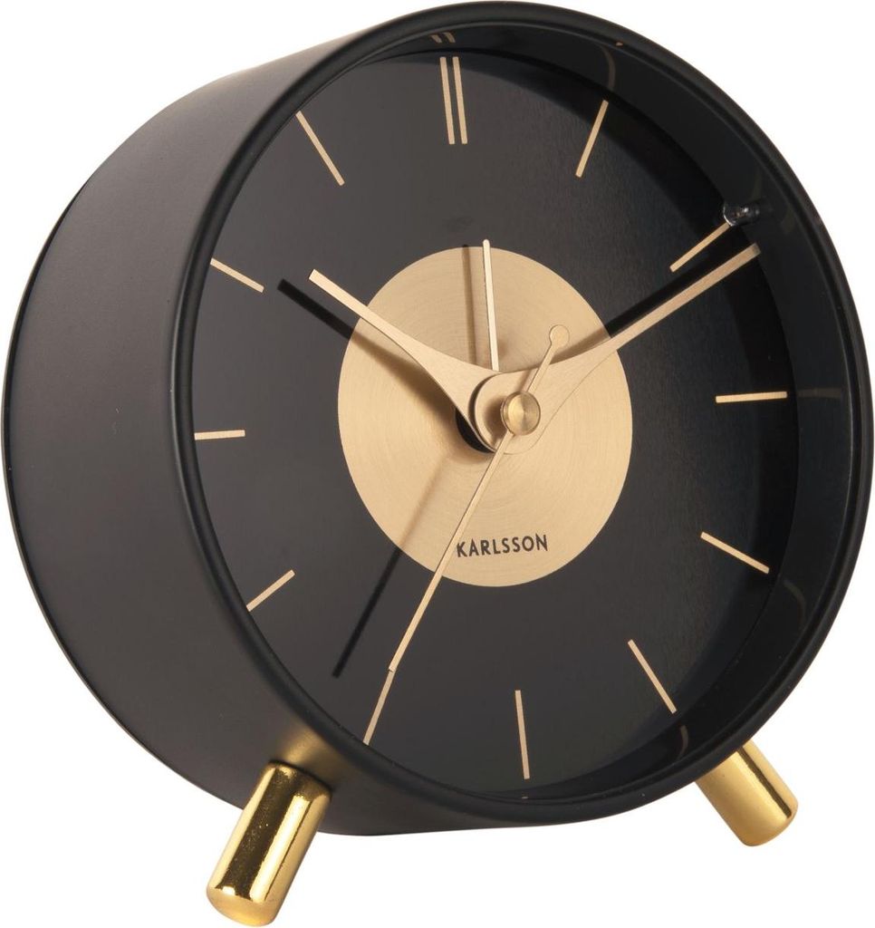 A close-up side view of a black Karlsson alarm clock with gold accents.