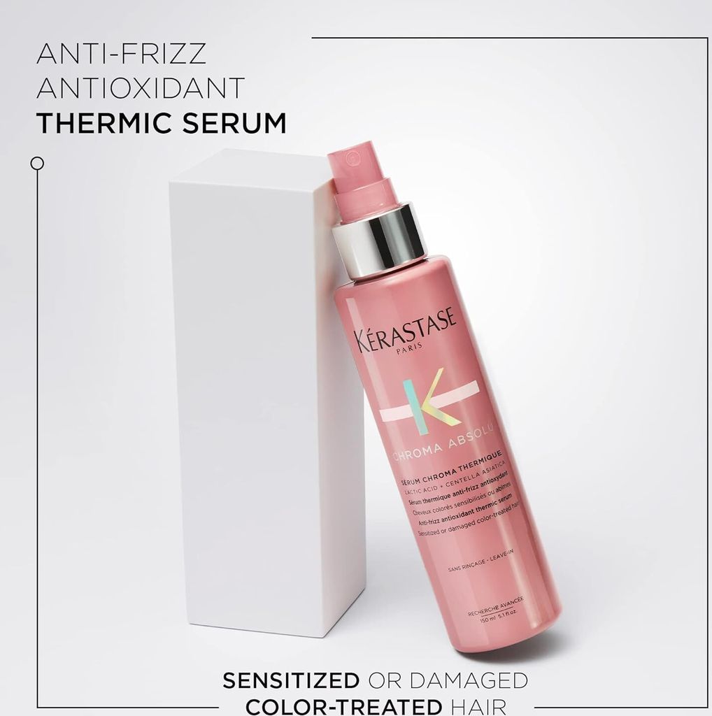 A pink bottle of Kérastase hair serum is leaning against a white geometric block, with text describing the product's benefits.
