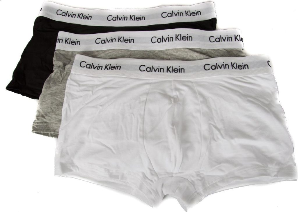 Three Calvin Klein boxer shorts are stacked on top of each other against a white background.