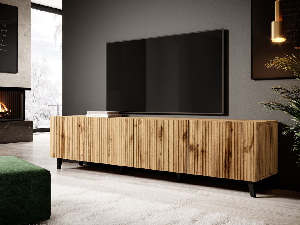 A modern living room with a TV stand, TV, fireplace, and a green ottoman.