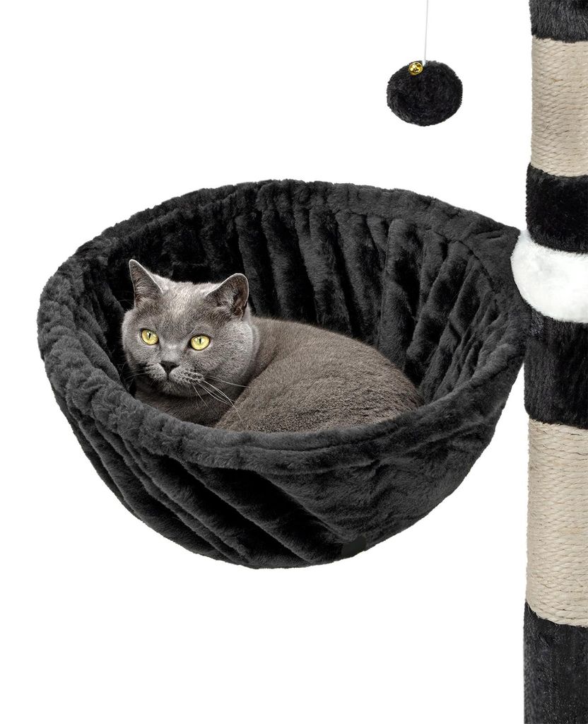 A cat is resting in a black hammock attached to a cat tree.