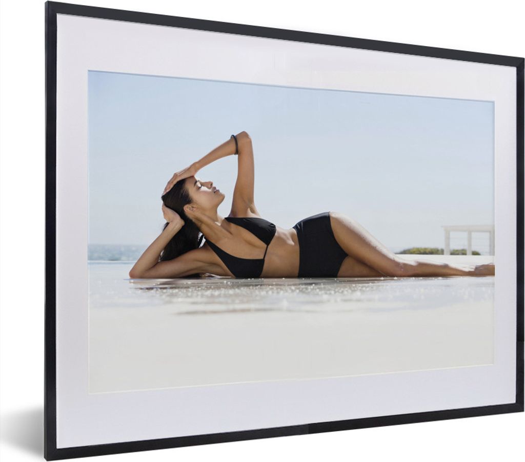 MuchoWow MuchoWow Gerahmtes Poster Eine Frau in einem schwarzen Bikini posiert am Strand 40x30 cm - Poster mit zchwarzem Bilderrahmen - Bilderr...
