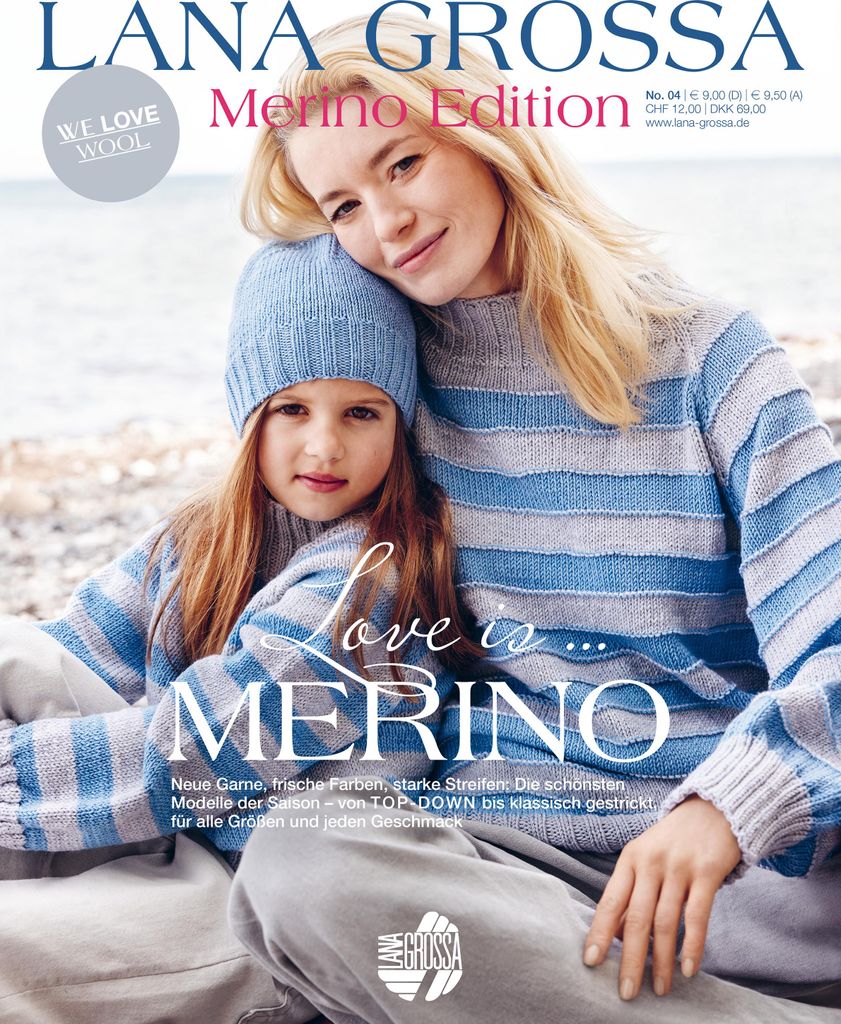 A mother and daughter are sitting together, both wearing matching striped sweaters and the daughter is wearing a hat. They are outdoors, possibly near a beach.