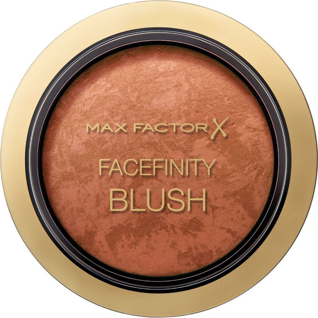 A close-up, top-down view of a round compact of blush with a gold-colored rim.