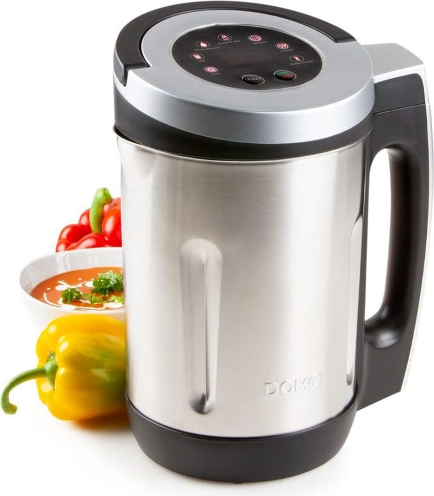 A soup maker with vegetables and a bowl of soup in the background.