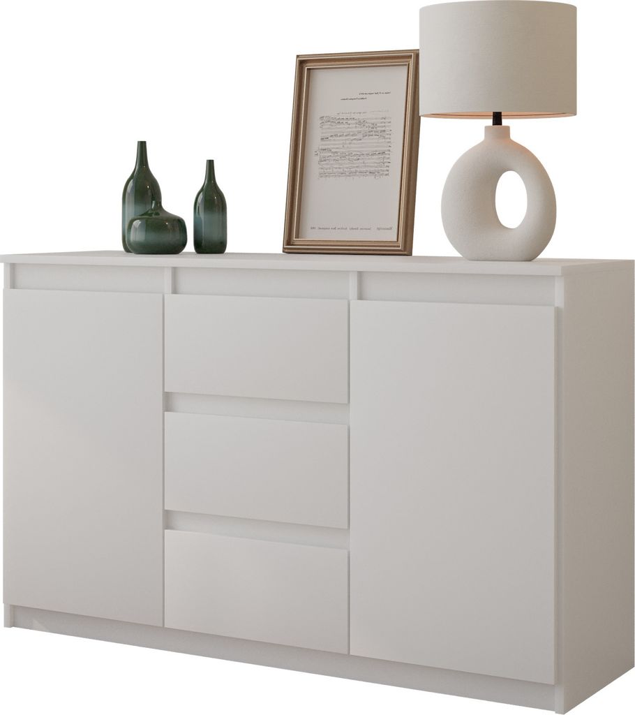 A white sideboard with decorative items on top, including bottles, a framed picture, and a lamp.