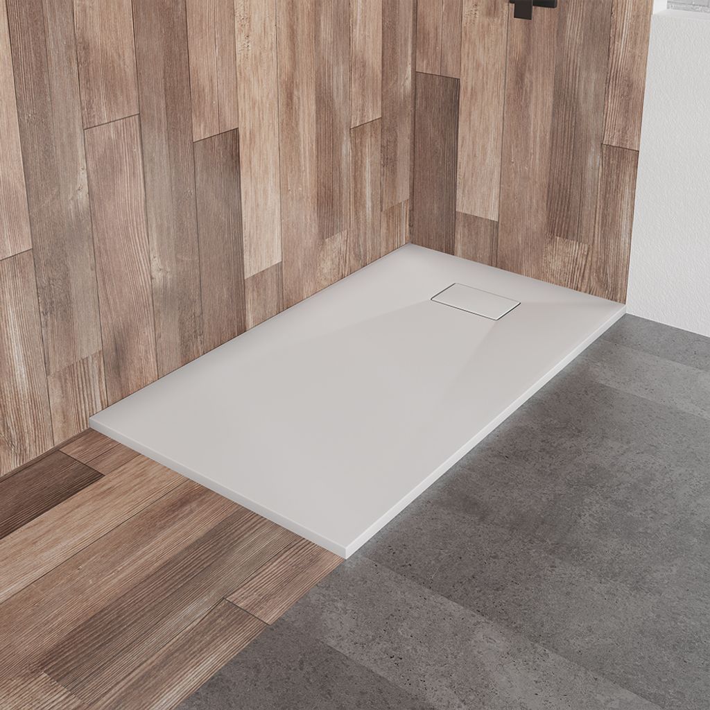 A modern shower tray with a wood-paneled wall and concrete floor.