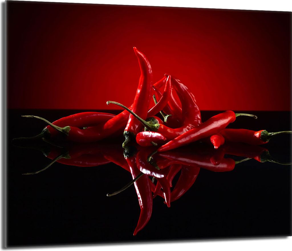 A group of red chili peppers arranged on a reflective black surface with a red background.