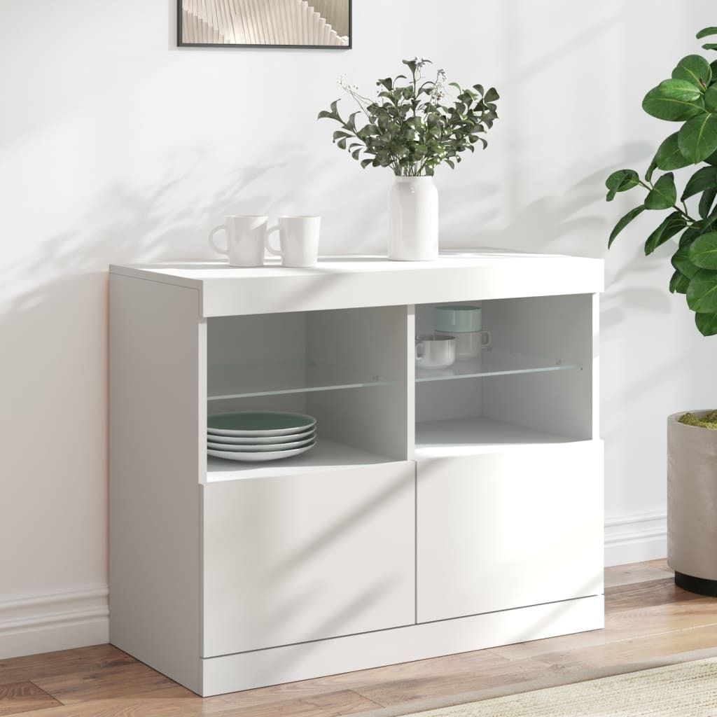 A white sideboard with various compartments and shelves, holding plates, cups, and decorative flowers.