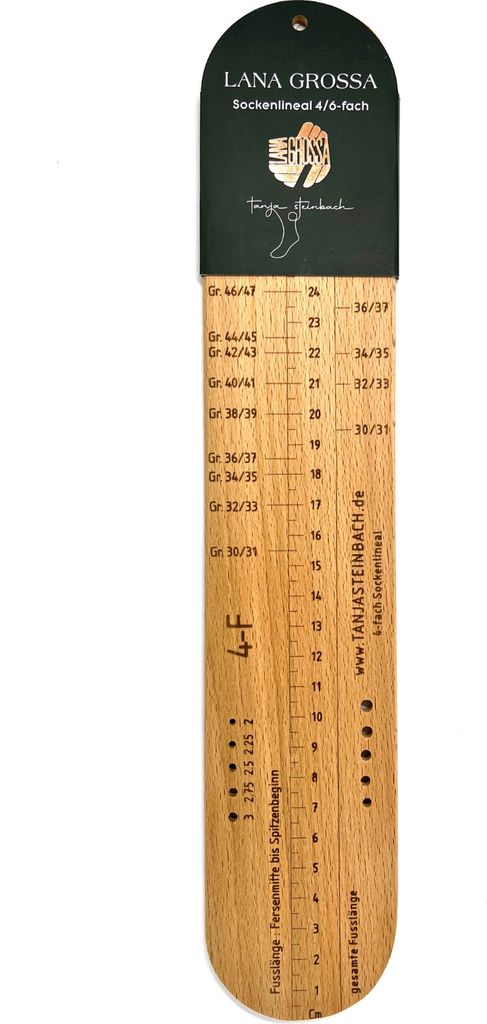 A wooden sock ruler with size markings and brand information.
