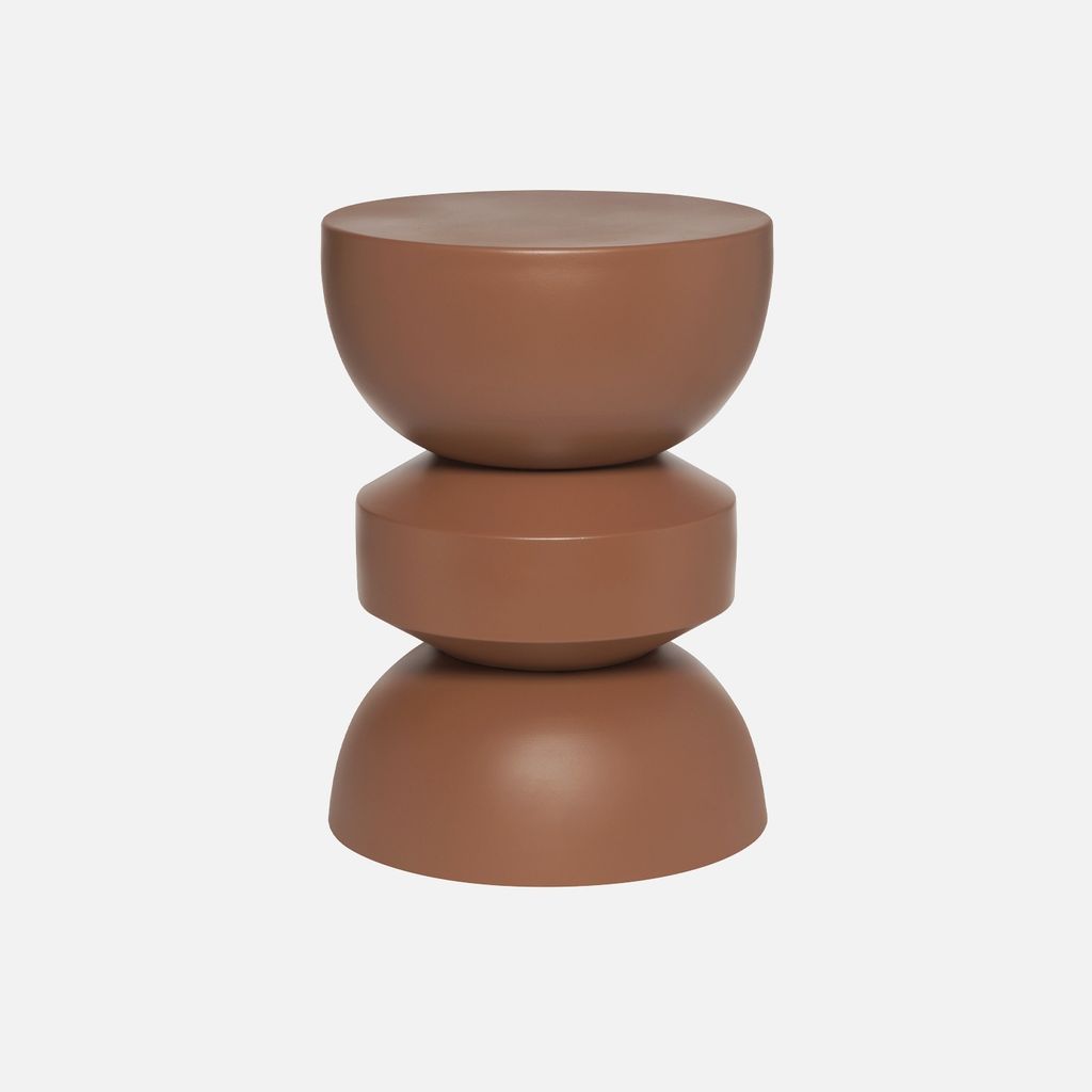 A terracotta-colored side table with a stacked, geometric design.